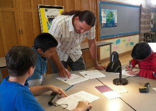 Instructor is helping students in a classroom.